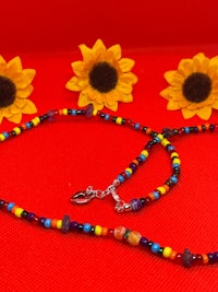 a colorful beaded necklace with sunflowers on a red background