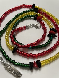 a red, yellow and green beaded necklace with a silver clasp